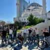 large group of men and on their self guided bike tour in front of the mosque of namazgad in tirana