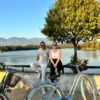 bike tour couple posing in the grand park of tirana with the lake and mountains in the backround